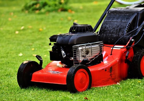 Red lawnmower mowing lawns in may